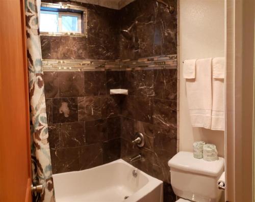 a bathroom with a tub and a toilet and a sink at Birch Creek #1 - 1BR/1BA - Down Canyon in June Lake