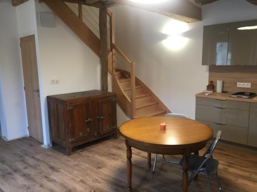 een keuken met een houten tafel en een houten trap bij En Rou Libre in Rou-Marson