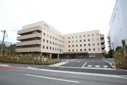 a large building with a parking lot in front of it at HOTEL EURASIA MAIHAMA ANNEX in Urayasu
