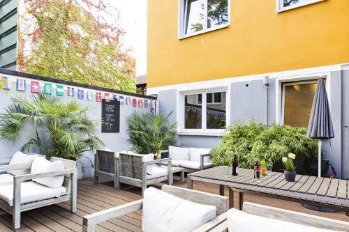 a patio with chairs and tables and a building at Five Reasons Hostel & Hotel in Nürnberg