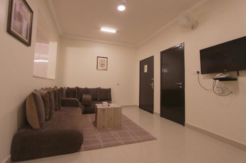 a living room with a couch and a tv at شقق منازل القصواء للشقق المخدومة إقتصادي in Buraydah