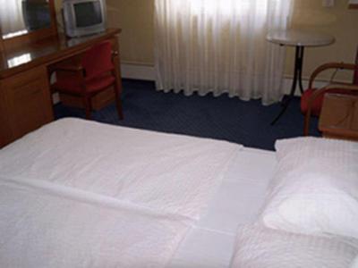 a bedroom with a bed and a desk and a television at Palma Panzio in Fót