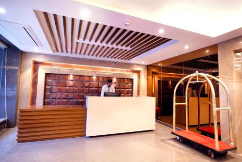 a man standing at a counter in a lobby at Hotel City Pride - City Centre, with Free Airport Pickup in New Delhi