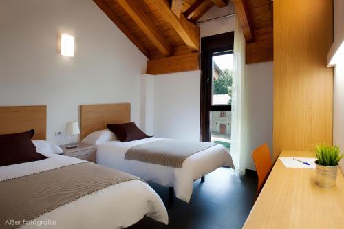 ビリャブリノにあるAlbergue Francisco Giner De Los Riosのベッド2台と窓が備わるホテルルームです。
