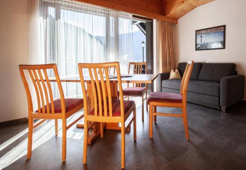 a living room with a table and chairs and a couch at Haus 4 Montafon by Pferd auf Wolke in Gaschurn