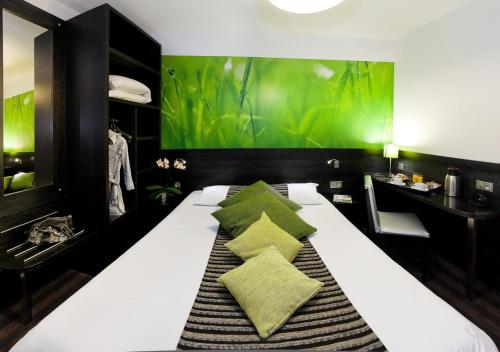 ショルジュにあるAx Hôtel Spa & Restaurantの緑の壁のベッドルーム1室(白い大型ベッド1台付)