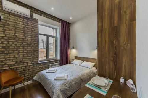 een slaapkamer met een bed en een bakstenen muur bij Kyiv City Loft Apart Hotel in Kiev