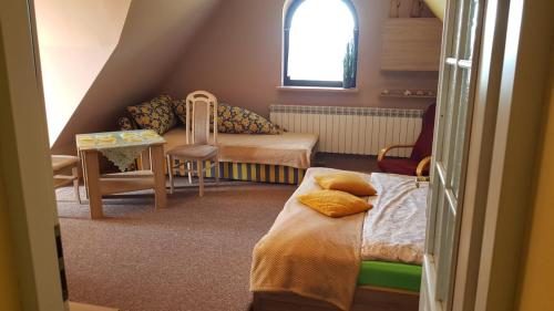 a small room with two beds and a table at Noclegi Barbara in Czorsztyn