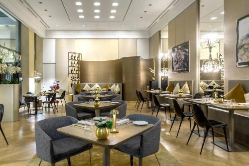 a dining room with tables and chairs and a restaurant at Rosa Grand Milano - Starhotels Collezione in Milan