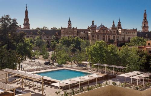 - un grand bâtiment avec une piscine en face dans l'établissement Melia Sevilla, à Séville