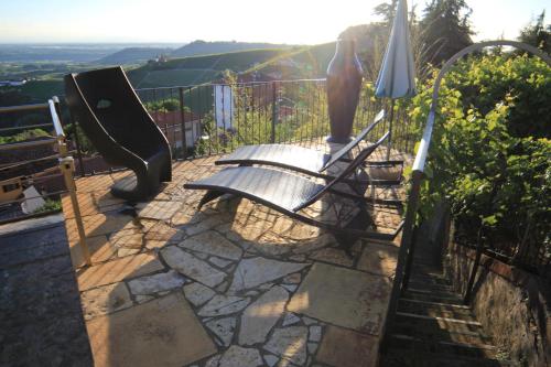 a bench sitting on top of a stone patio at Felicin - Palazzo Boeri Panoramic Suites in Monforte dʼAlba