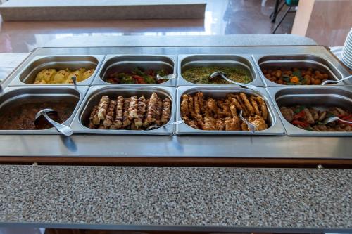 a tray of different types of food on a table at Hotel Poienița in Baile Felix