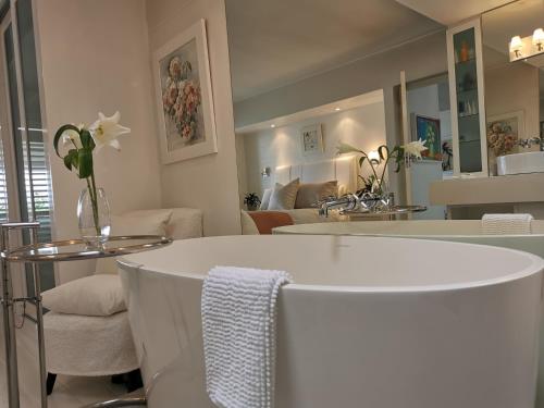 a bathroom with a sink and a living room at Village Square 10 in Plettenberg Bay