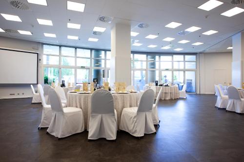 a conference room with white tables and chairs and a screen at Eurostars Don Cándido in Terrassa