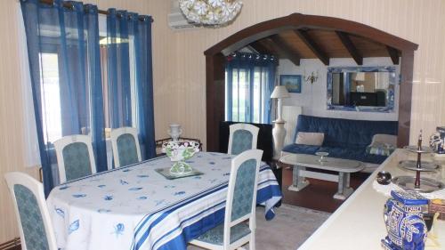 un soggiorno con tavolo e divano blu di Holiday Home Filie a Andernos-les-Bains