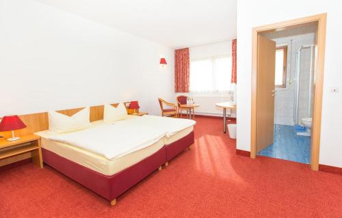 Habitación de hotel con cama, mesa y sillas en Steigerwaldpension, en Wiesentheid