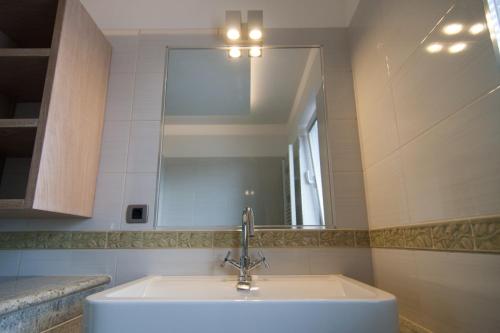 uma casa de banho com um lavatório e um espelho em Exclusive Apartments DEBELI RTIČ em Ankaran