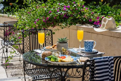 ein Tisch mit einem Teller Essen und zwei Gläsern Orangensaft in der Unterkunft Prima Royale Hotel in Jerusalem