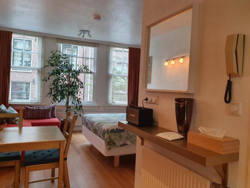 a hotel room with a bed and a table and a desk at Huis Roomolen in Amsterdam
