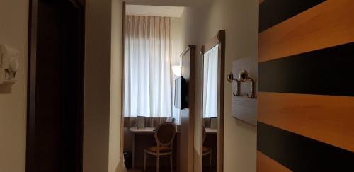 a bathroom with a toilet and a table and a window at Santa Barbara Hotel in San Donato Milanese