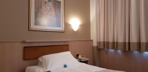 a bedroom with a bed and a picture on the wall at Santa Barbara Hotel in San Donato Milanese