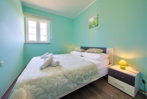 a blue bedroom with a large bed and a window at Villa Vrh in Krk