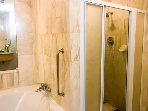 a bathroom with a shower and a bath tub at Fortune Hotel Korat- SHA Plus in Nakhon Ratchasima