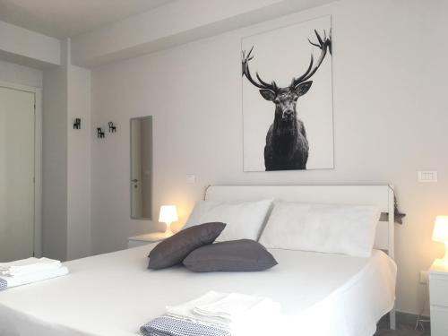 a bedroom with a bed with a deer picture on the wall at Deer House BnB in Coppito