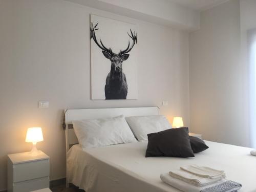 a bedroom with a bed with a deer head on the wall at Deer House BnB in Coppito