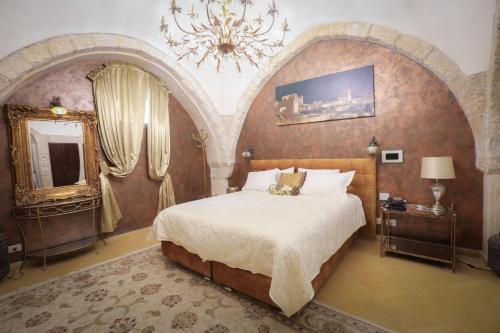 ein Schlafzimmer mit einem großen Bett und einem Kronleuchter in der Unterkunft Western Wall Luxury House in Jerusalem
