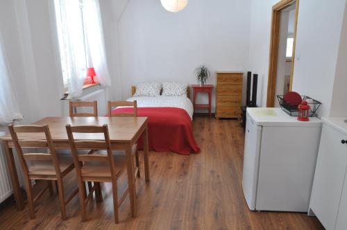 a bedroom with a bed and a table and chairs at Leśne Apartamenty in Zieleniec