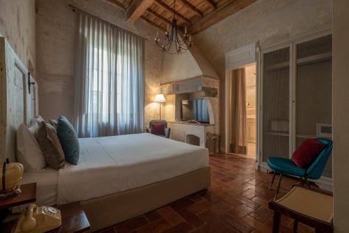 フィレンツェにあるレジデンツァ ラ ムーザ アマルコルドのベッドルーム(白いベッド1台、青い椅子付)