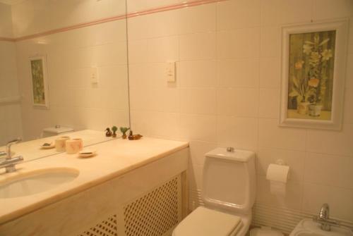 bagno con lavandino, servizi igienici e specchio di Akisol Vilamoura Hill a Vilamoura