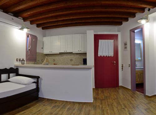 um quarto com uma porta vermelha e uma cozinha em Nicolas House em Rakhídhion
