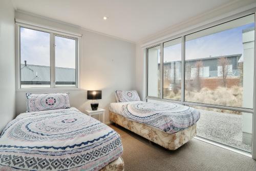 a bedroom with two beds and a large window at Queenie's Lakeview Star in Lake Tekapo