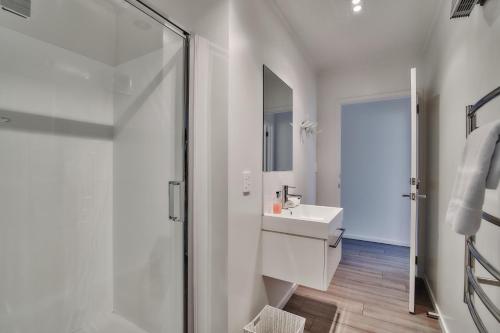 a white bathroom with a sink and a shower at Queenie's Lakeview Star in Lake Tekapo