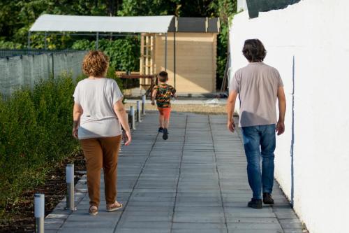 two adults and a child walking down a sidewalk at Veda elegant rooms in Fiumefreddo di Sicilia