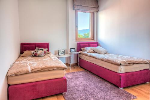 a bedroom with two beds and a window at VIP Apartments in Sarajevo