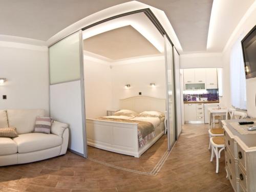 a bedroom with a bed and a living room at Exclusive Apartments DEBELI RTIČ in Ankaran
