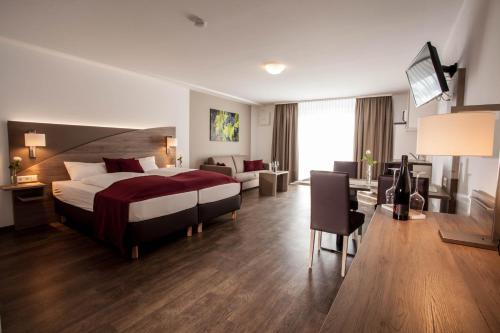 een hotelkamer met een bed en een woonkamer bij Wein & Bett Weihbrecht in Bretzfeld