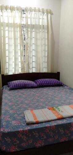 a bed in a bedroom with a window with curtains at HOMESTAY AQILAH PASIR PUTEH KELANTAN in Pasir Puteh