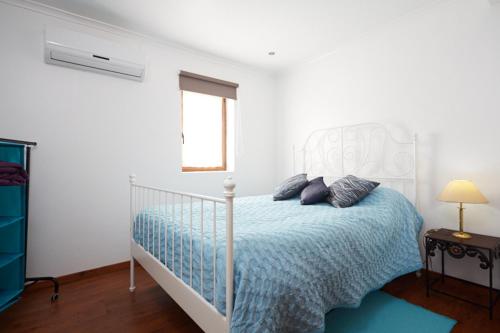 a white bedroom with a bed with a white canopy at Casa Nascente - Água Formosa _ Vila de Rei in Vila de Rei