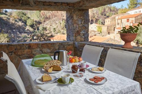 a table with plates of food and a watermelon at Casa Nascente - Água Formosa _ Vila de Rei in Vila de Rei