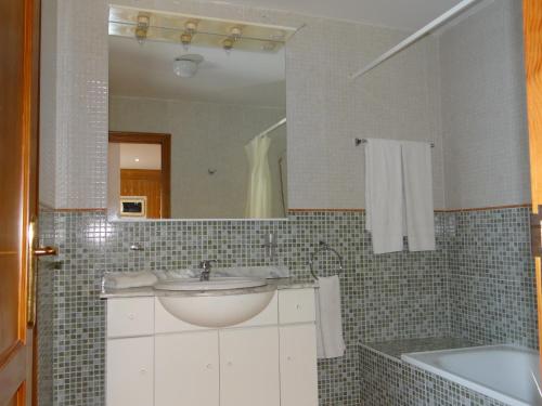 y baño con lavabo, bañera y espejo. en Apartamentos Lanzarote Paradise Colinas, en Costa Teguise