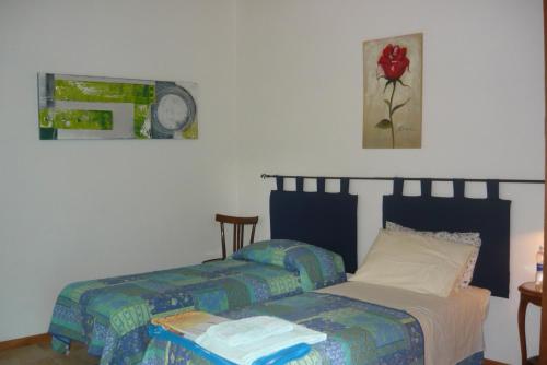 a bedroom with two beds and a clock on the wall at B&B Santu Larentu in Ozieri