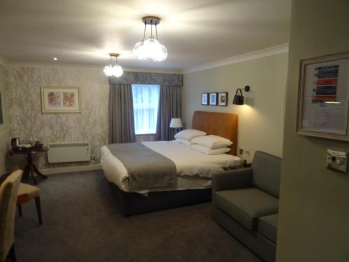 a hotel room with a bed and a chair at The Belmore in Sale