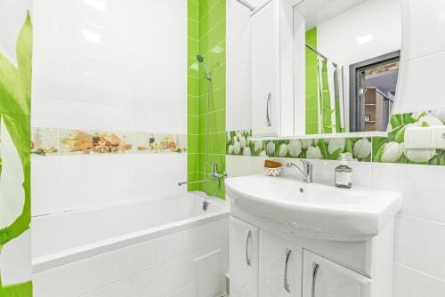 uma casa de banho com um lavatório, uma banheira e um espelho. em Apartments on the Black Sea em Odessa