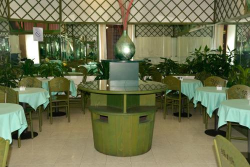 ein Restaurant mit Tischen und Stühlen und einer Vase in der Mitte in der Unterkunft Hotel Amadeus E Teatro in Turin