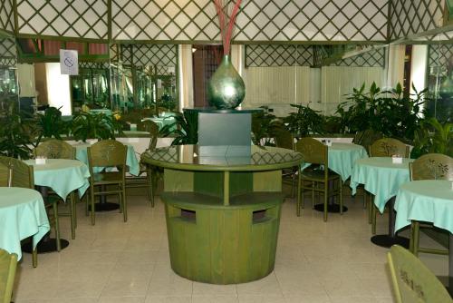 a restaurant with tables and chairs and a vase in the middle at Hotel Amadeus E Teatro in Turin