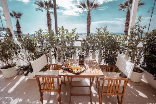 een tafel en stoelen op een patio met palmbomen bij Break for two in Agropoli
